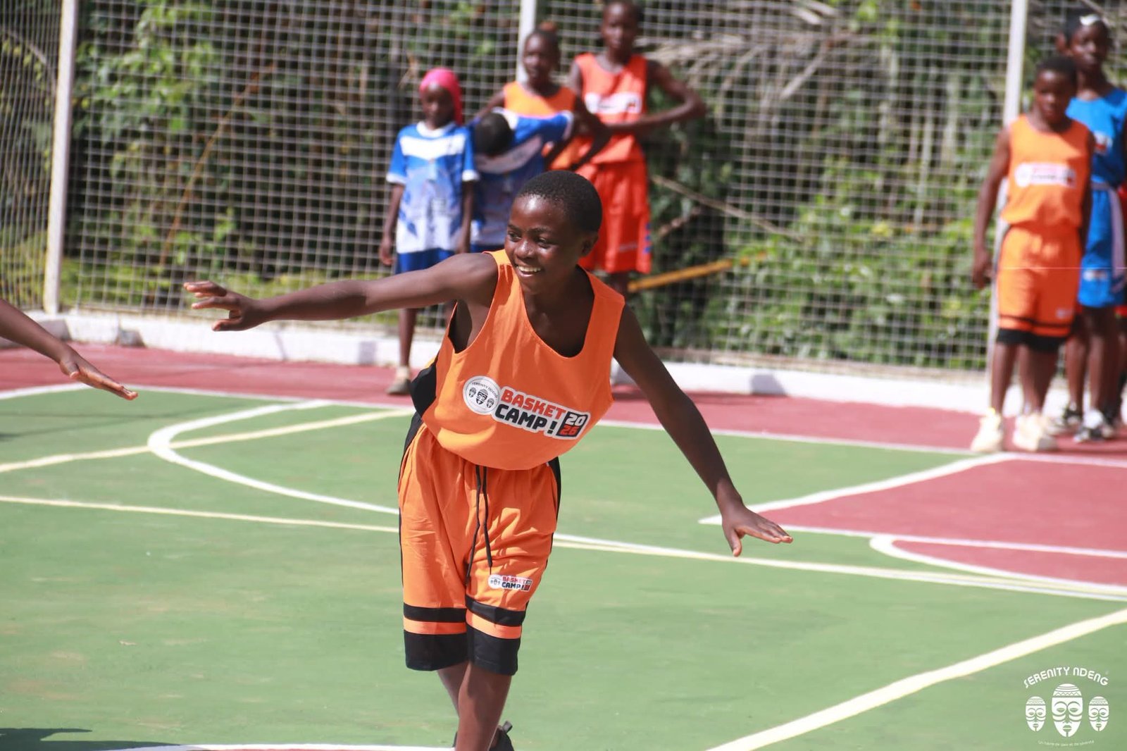 Élève souriante en action pendant le camp de basket