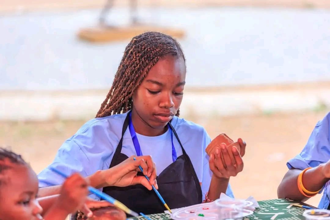 Enfant peignant un objet artisanal lors d'un atelier